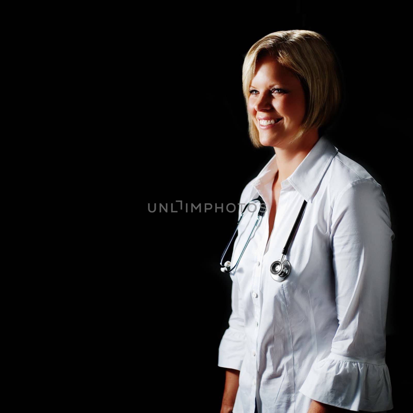 Mature woman doctor against black with stethoscope.