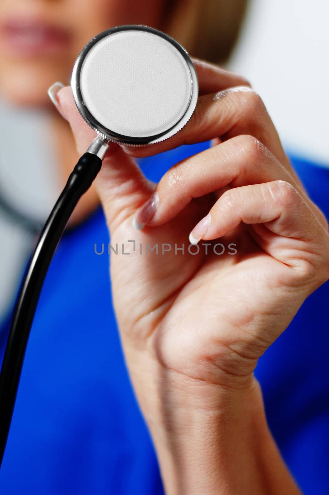 Close up shot of woman holding up a stethoscope.