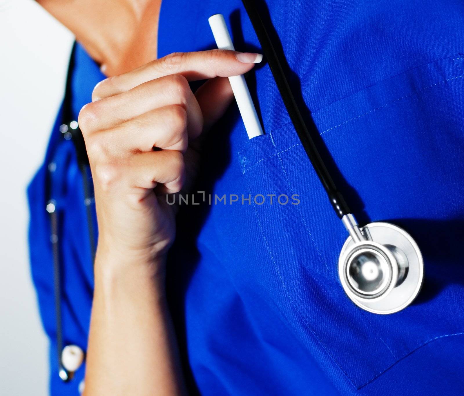 Woman nurse in scrubs reaching for a pen.