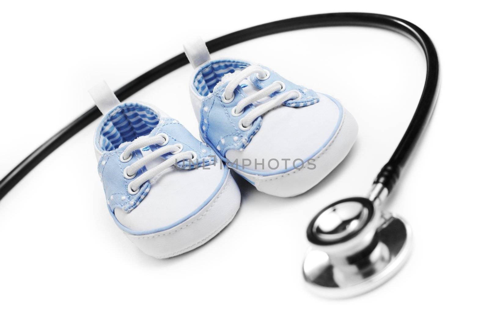 Baby shoes with stethascop against a white background.