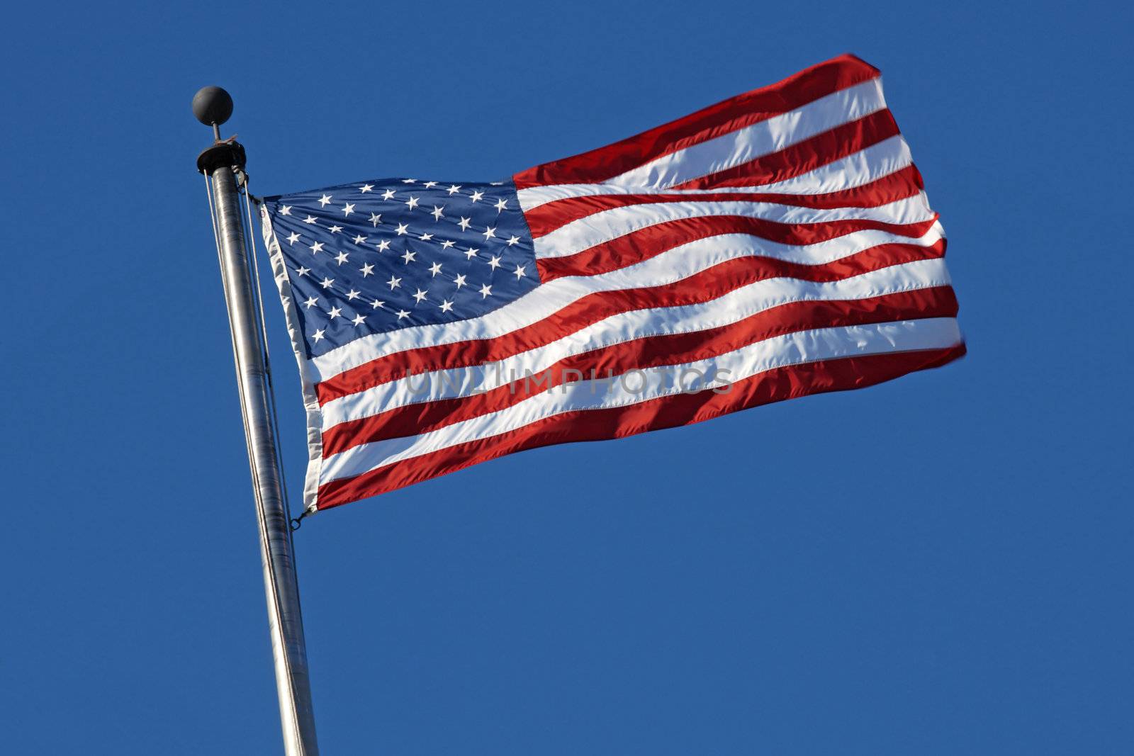 Photo of the American flag blowing in the wind.