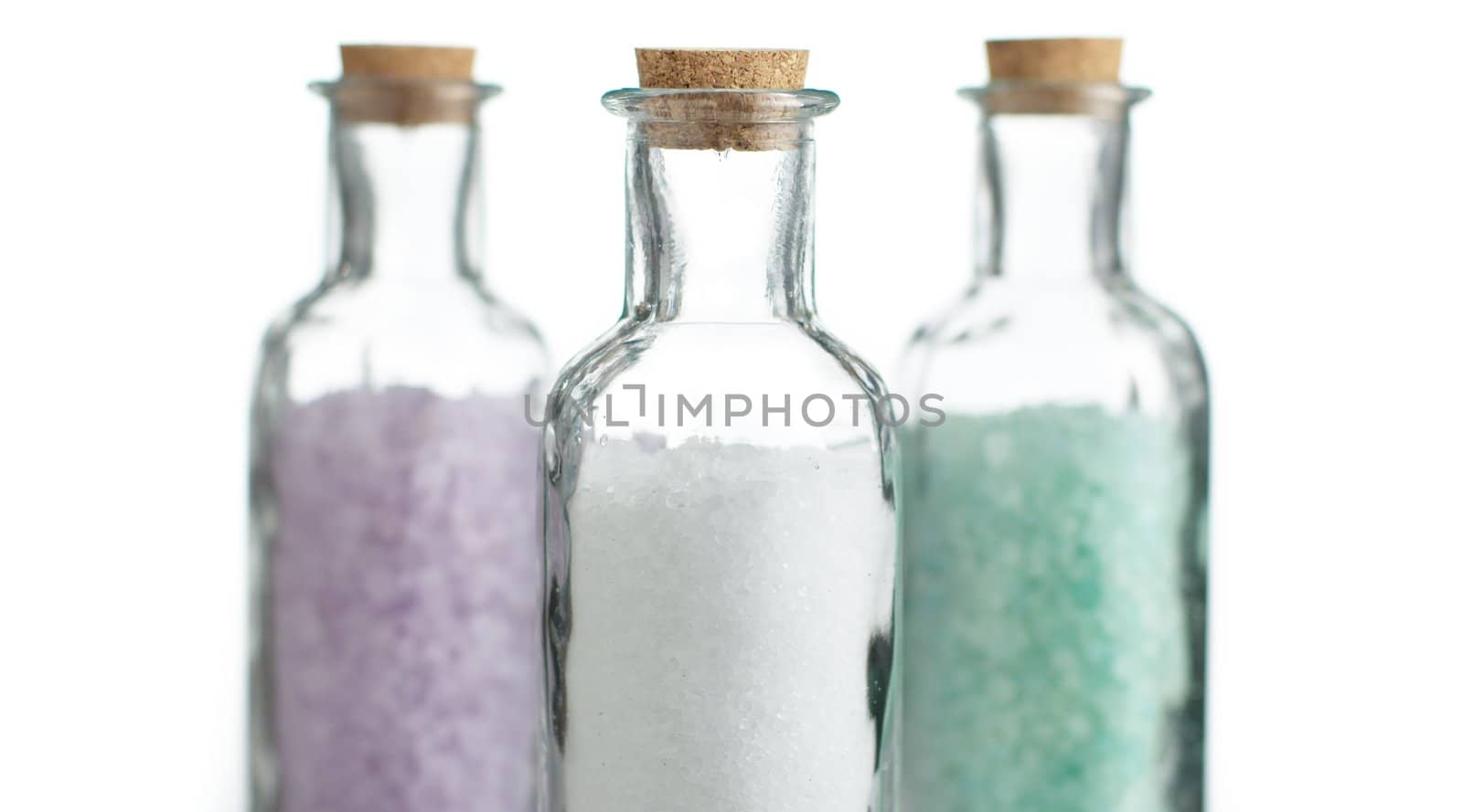 Colored bath salt against a white background.