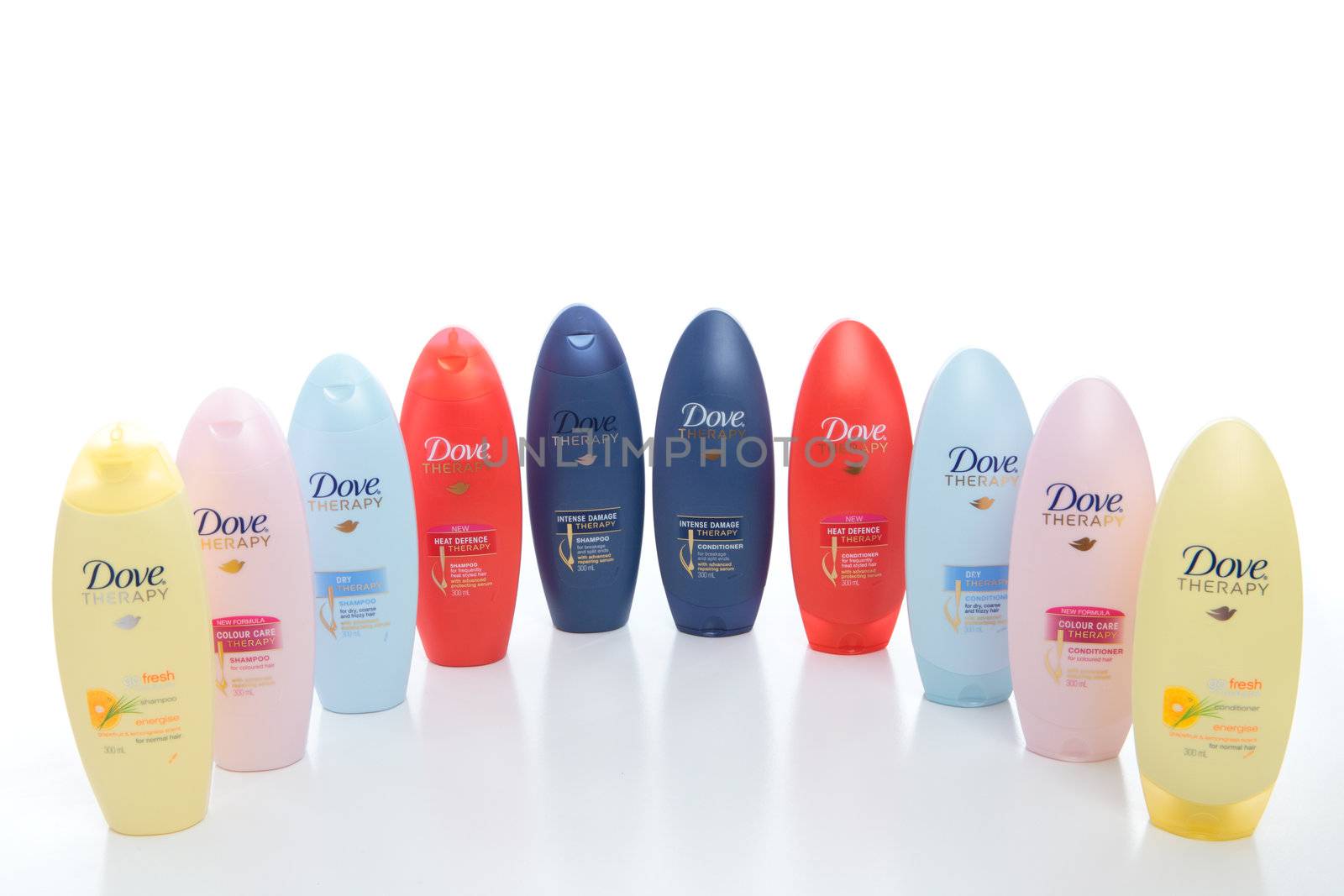 A variety of Dove Therapy shampoos and conditioners on a white background.   