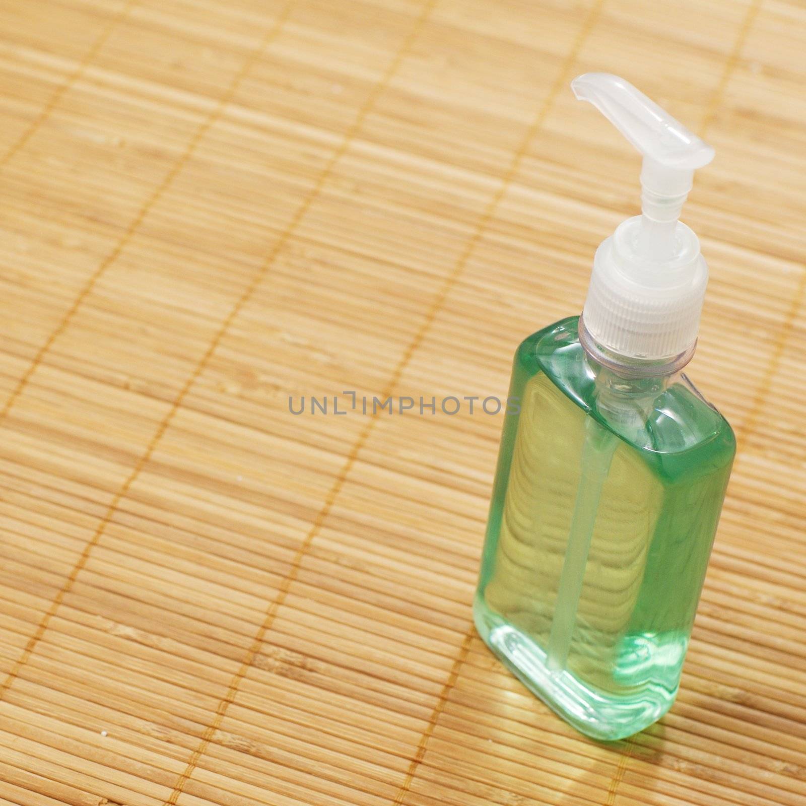 A soap bottle on display against a bamboo mat.