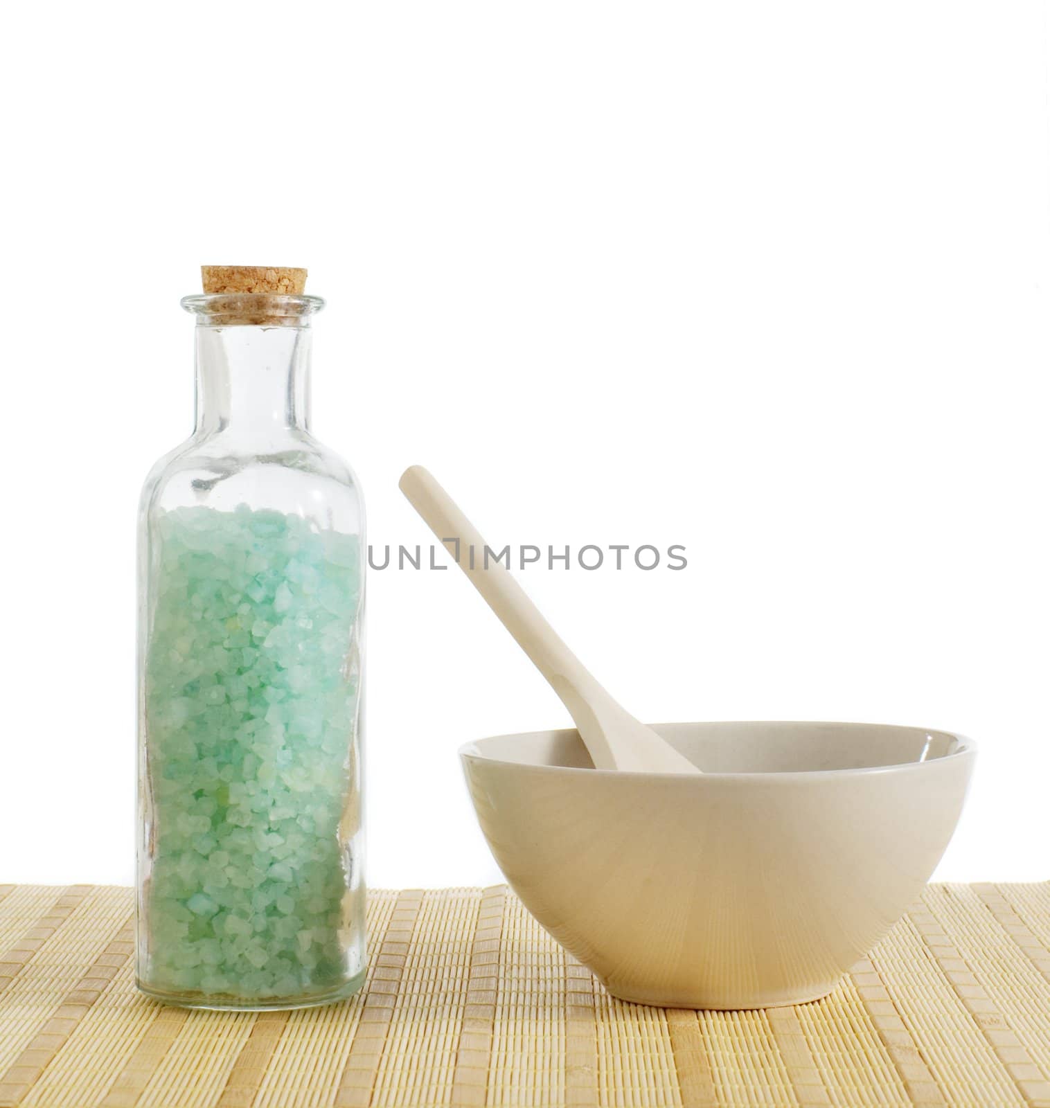 Bottle of salt and bowl of treatment against a white background.