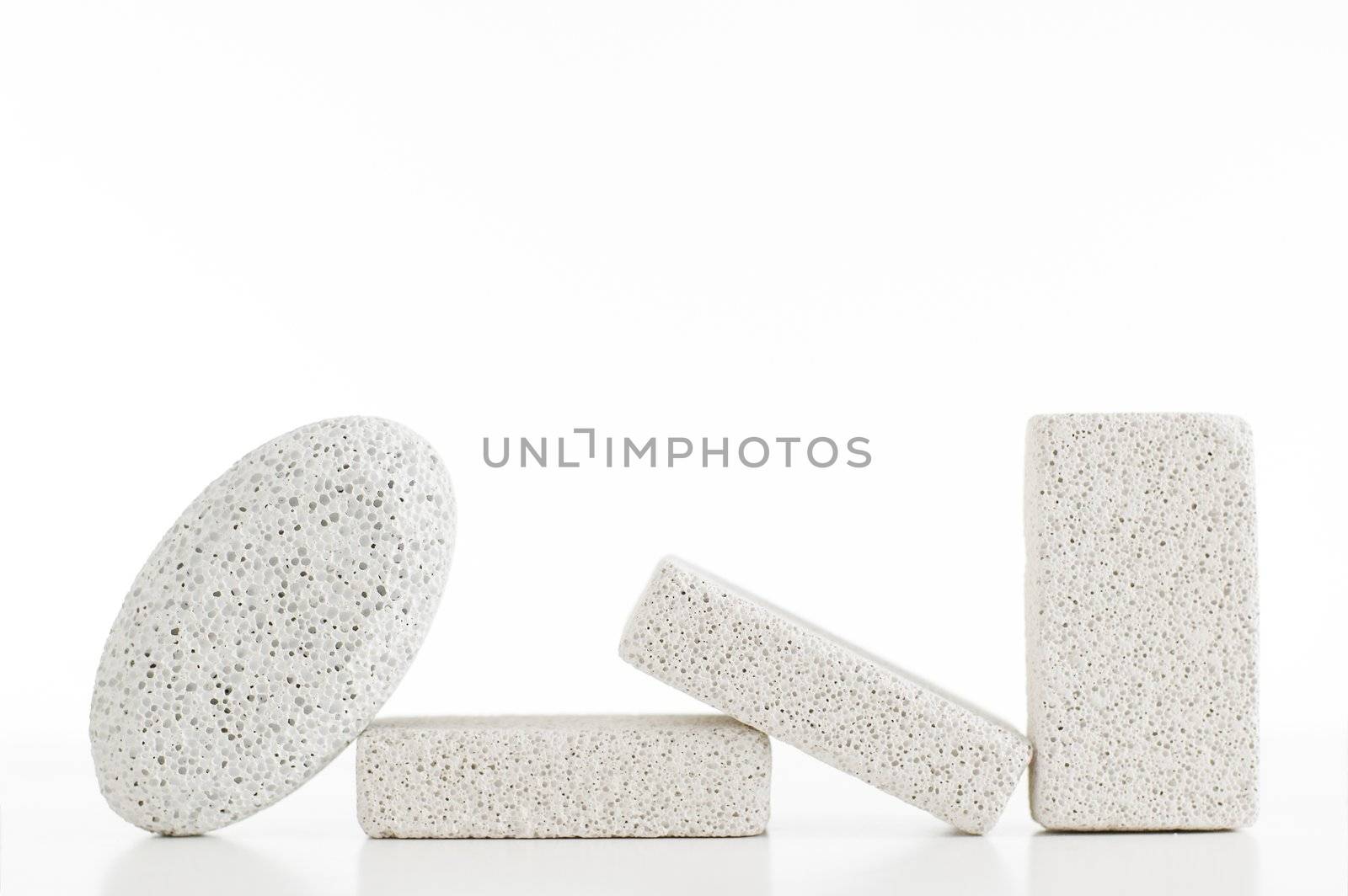 Pumice stones against a white background, sleight reflection.