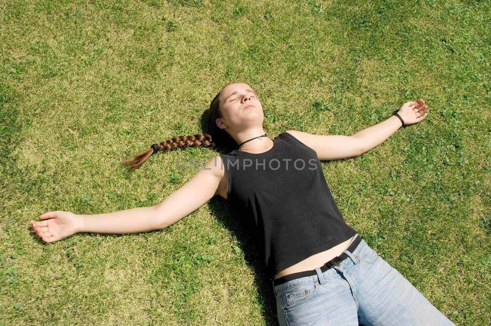 Girl laying on the green grass, relaxing