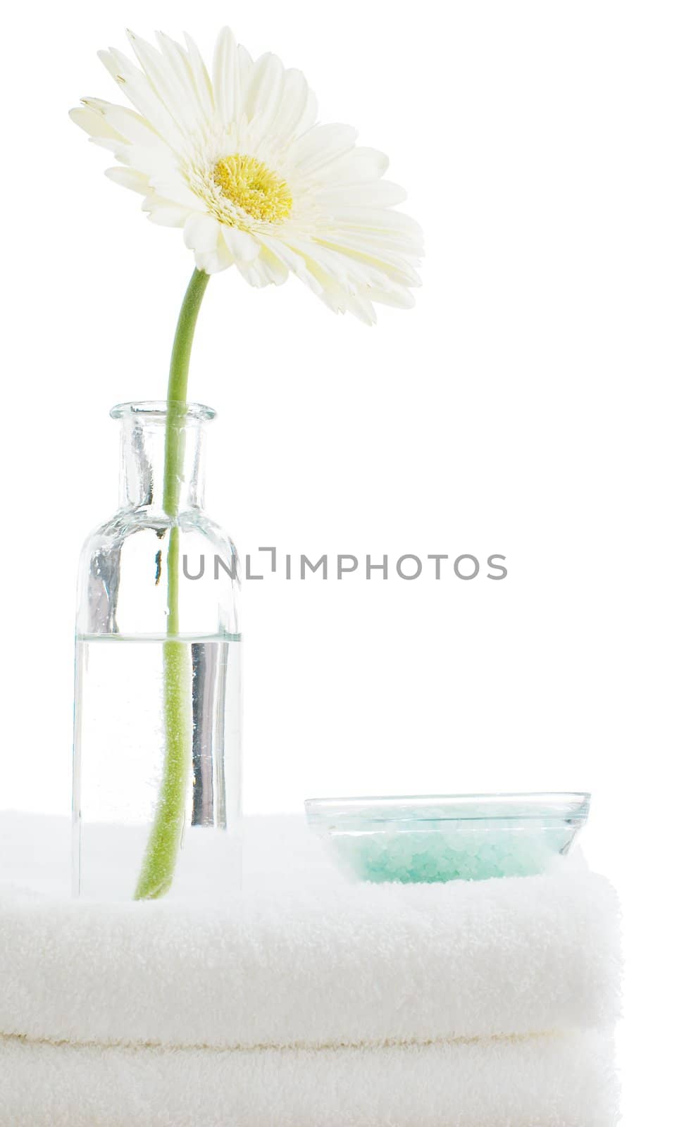 Towel stack with spa objects against a white background.