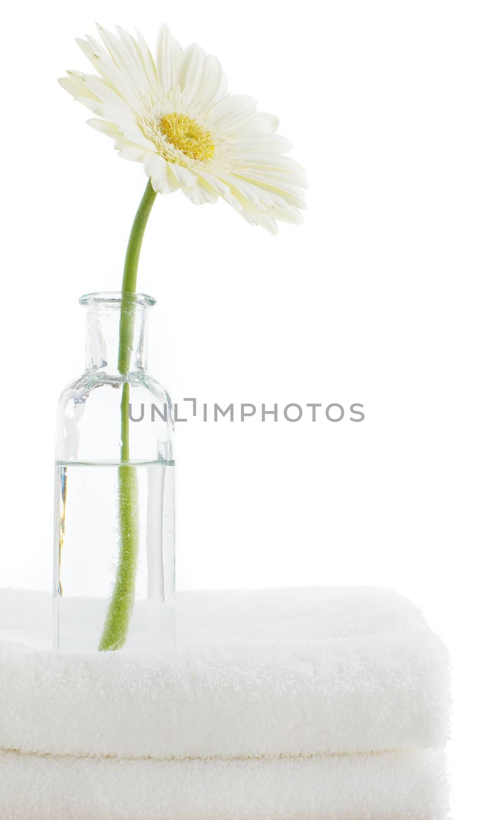 Towel stack with spa objects against a white background.