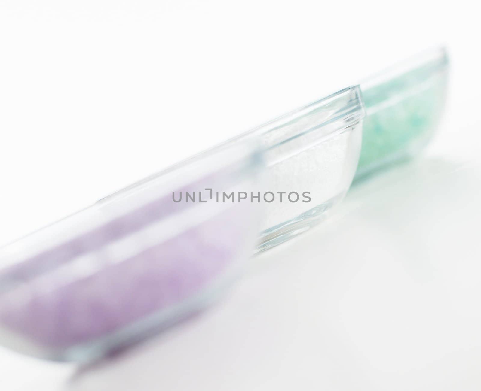 Bowls of colorful bath salt against a white background.