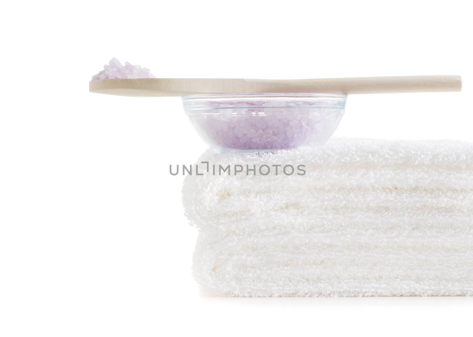 Towels and bath salt being displayed against a white background.
