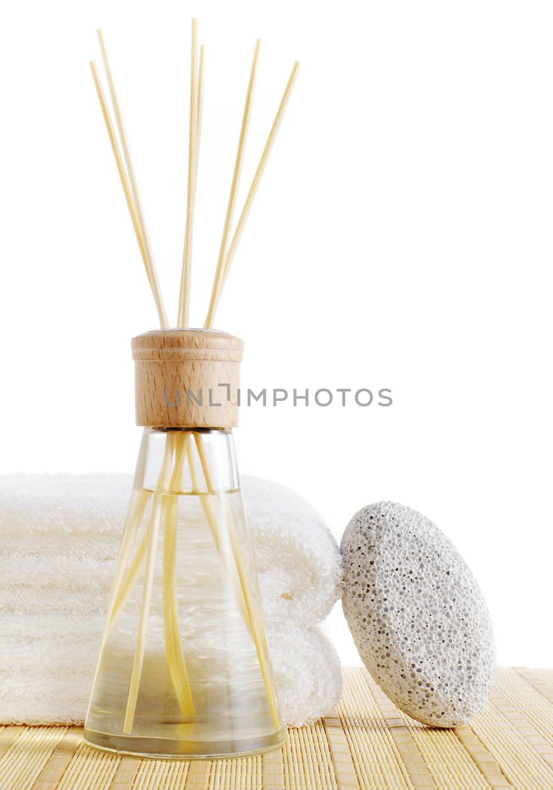Diffuser, towels, and pumice stone against a white background.