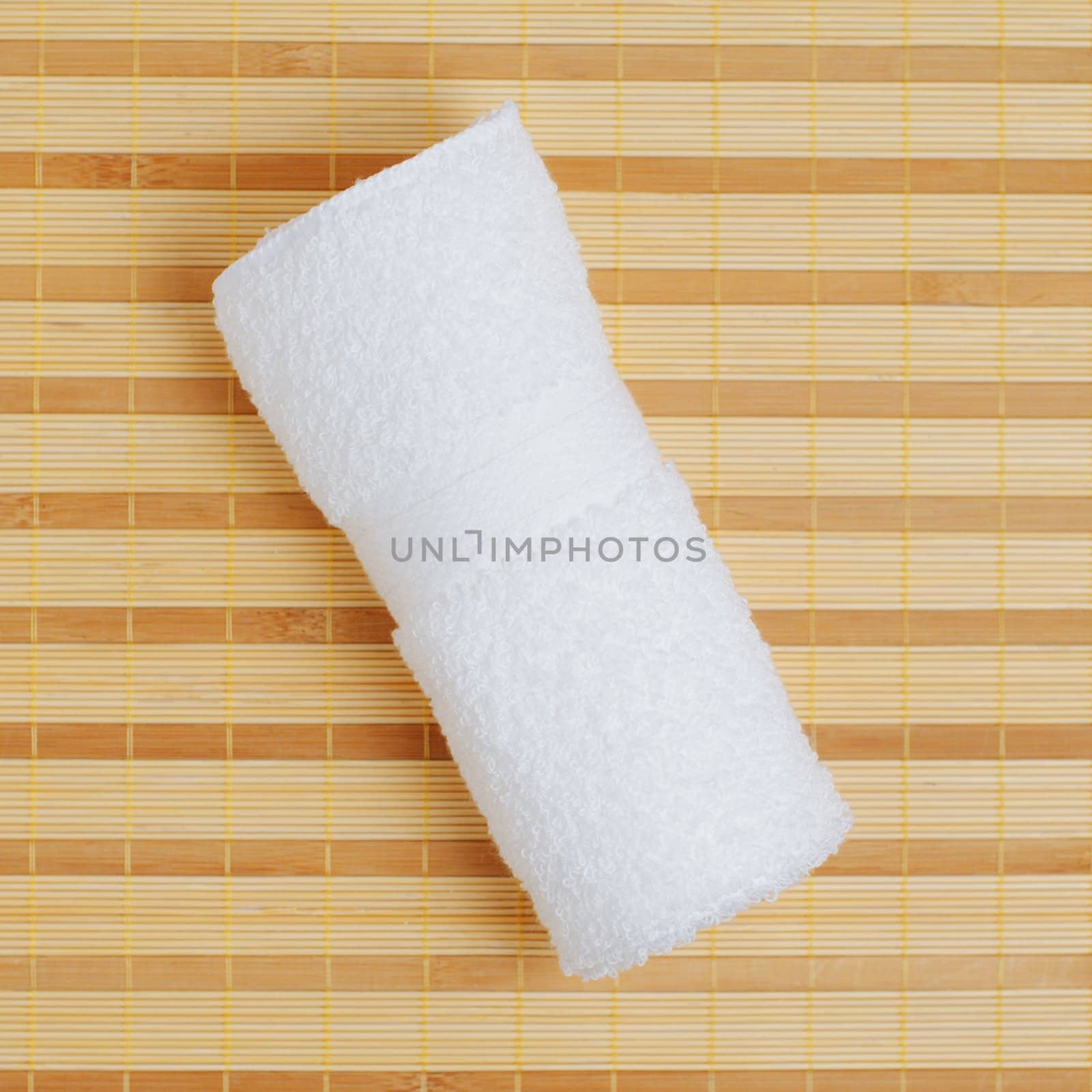 White towel against bamboo reed mat background.