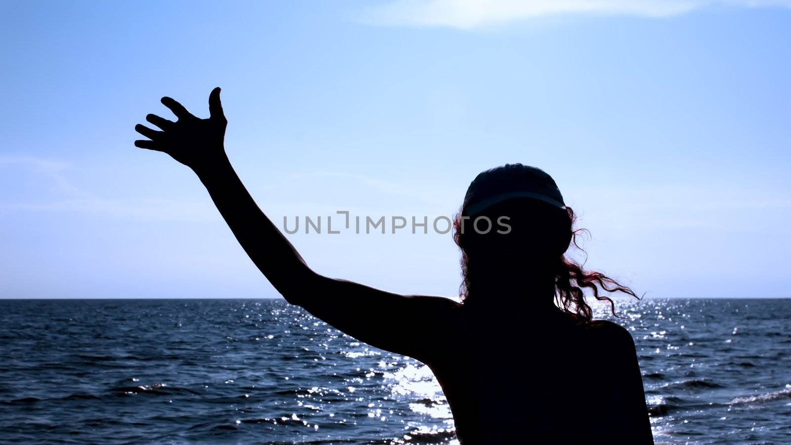 Silhouette of woman against the sea in the evening