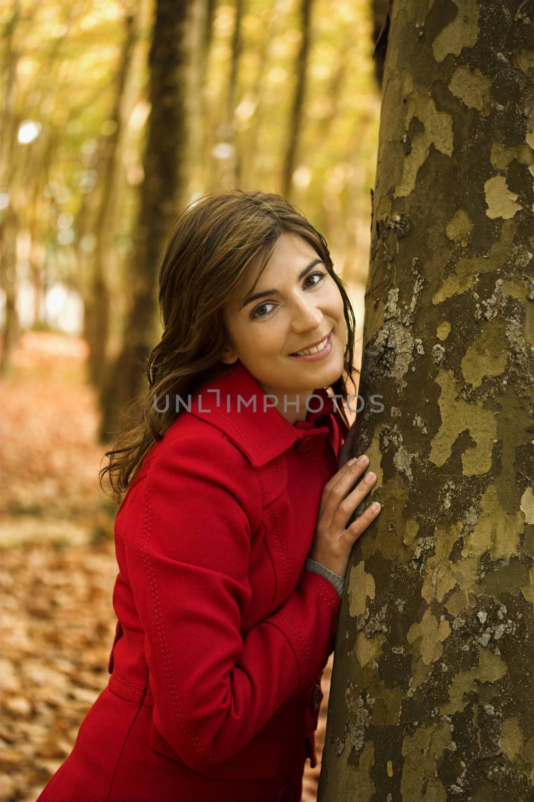 Portrait of a beautiful young woman relaxing close to a tree