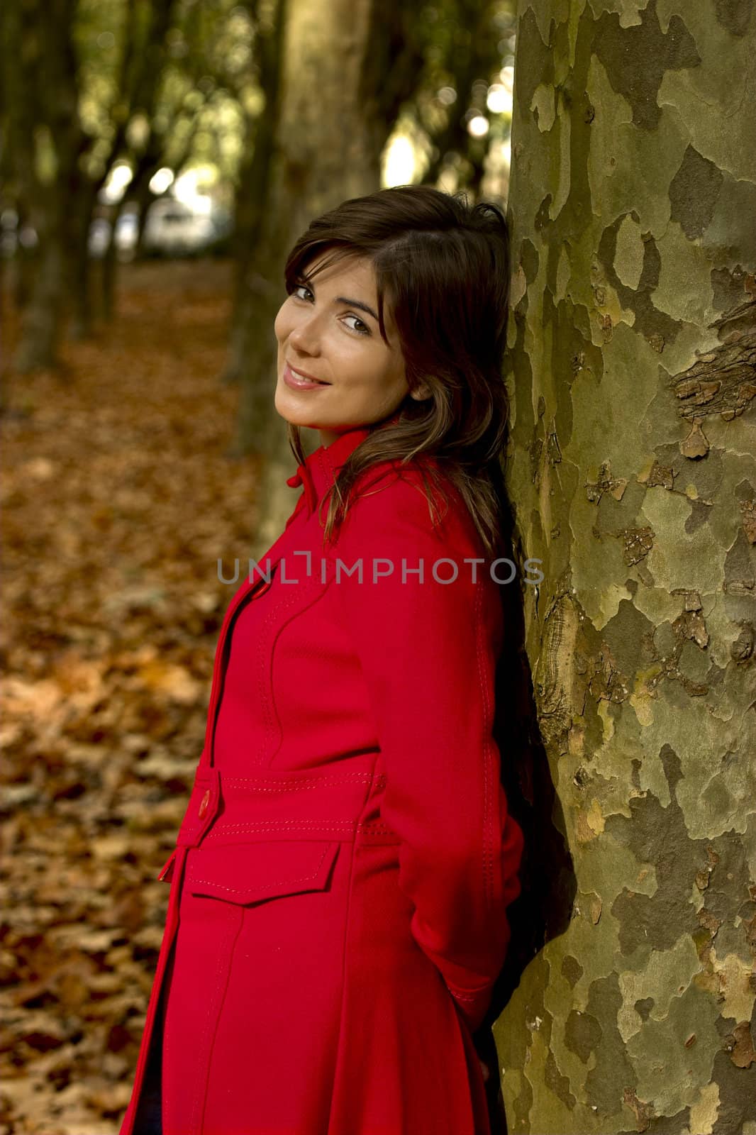 Portrait of a beautiful young woman relaxing close to a tree