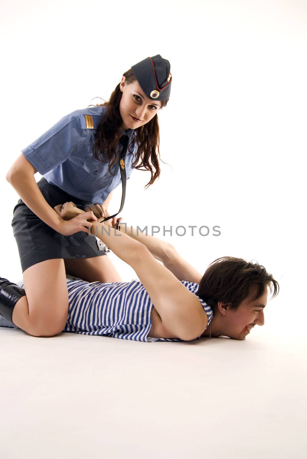 Young woman in police uniform arresting a criminal