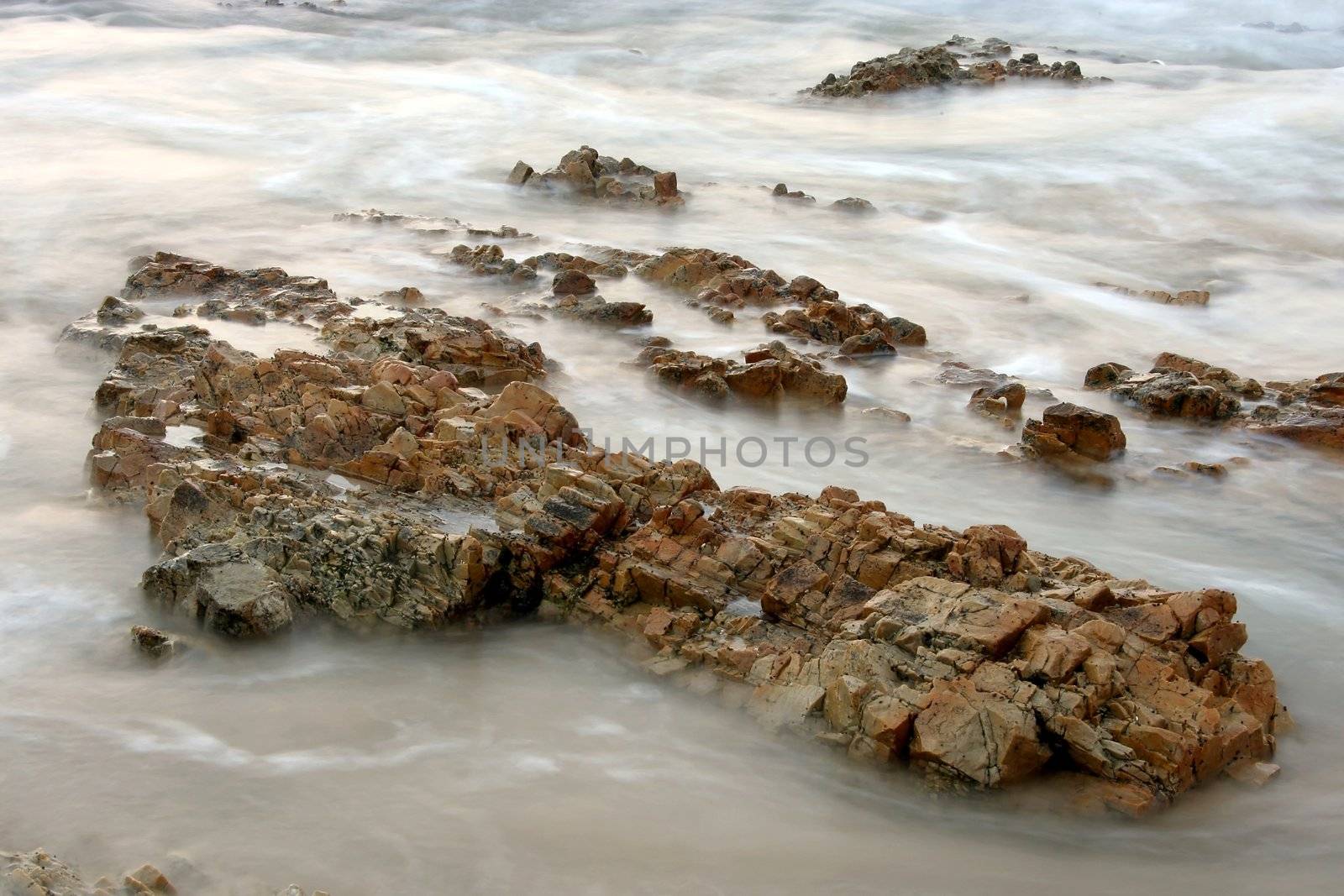 Sea rushing in and swirling over and around rocks