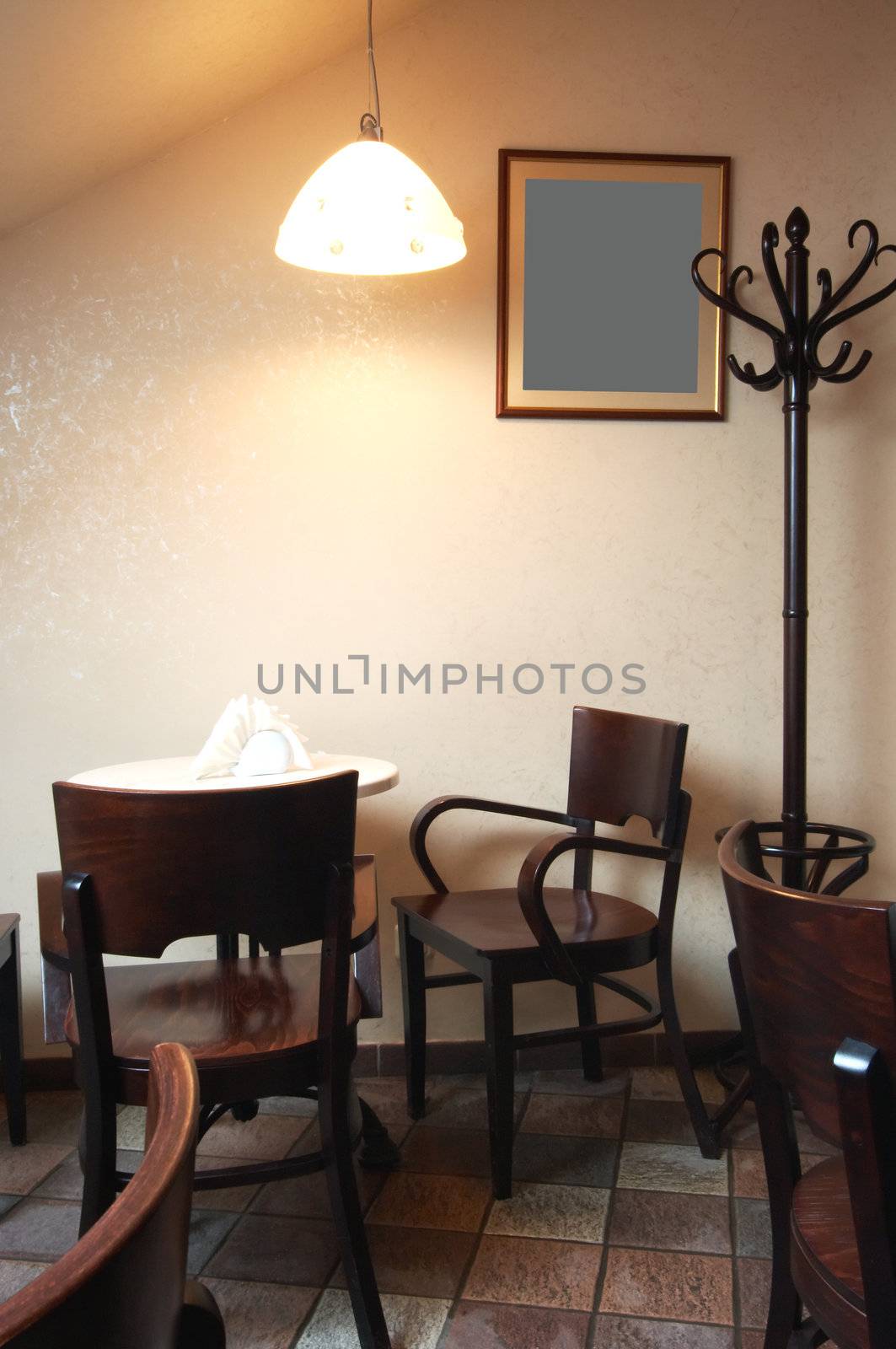 Table and chairs under a lamp in cafe