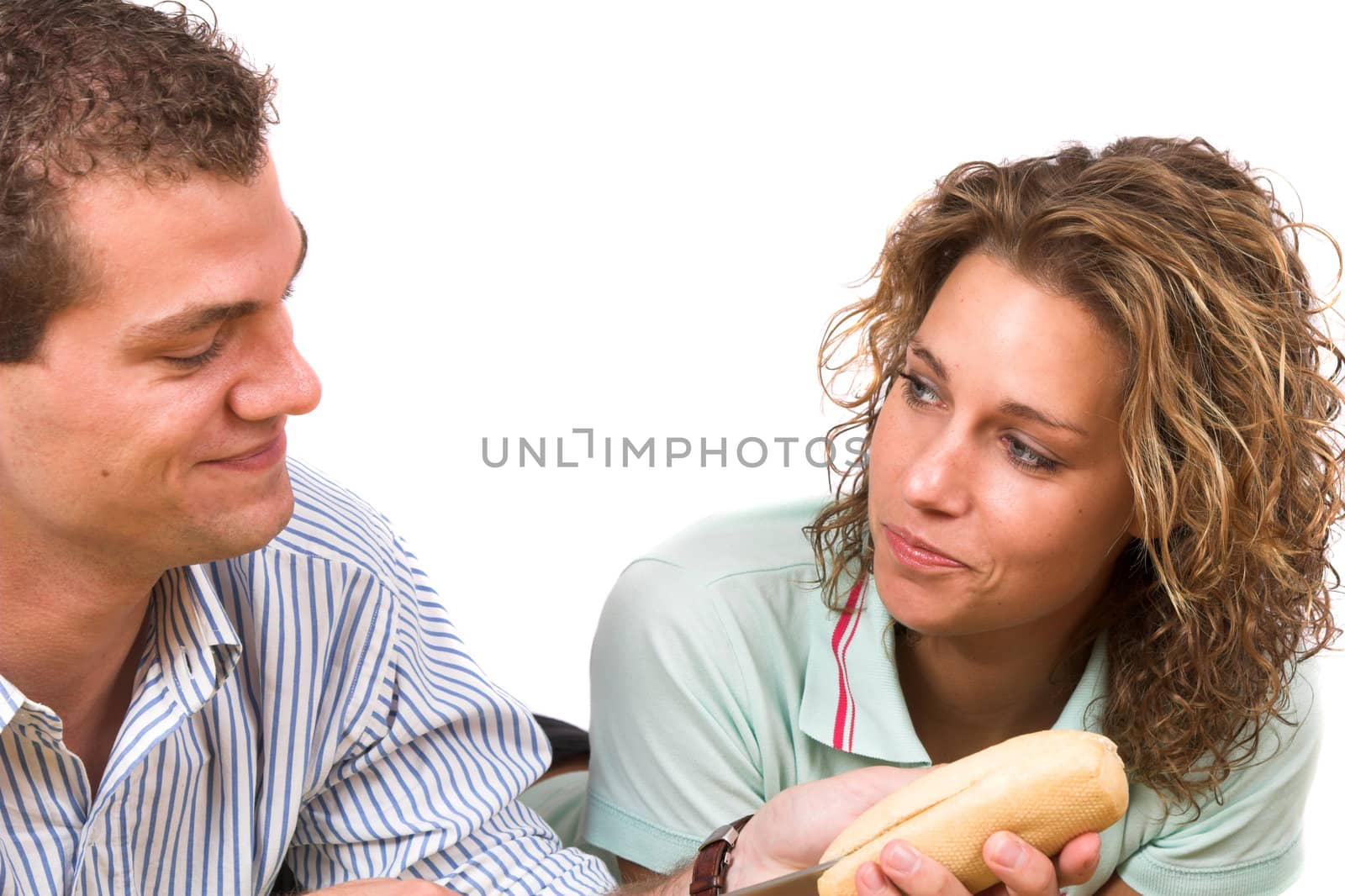 Man cutting the bread while his girlfriend is watching