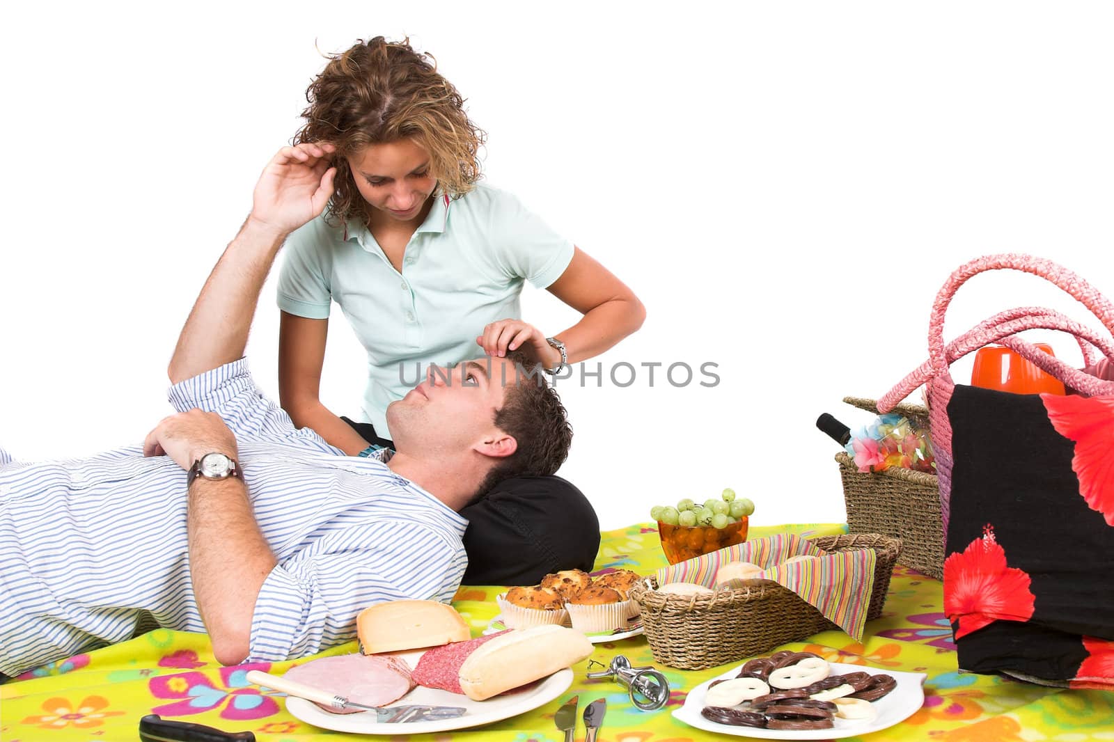 Sweet young couple together on a picnic, stroking eachother lovingly through the hair