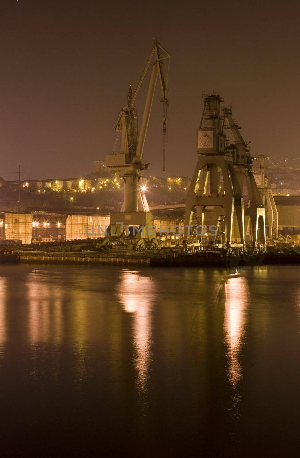 industrial image of cranes and factories at night