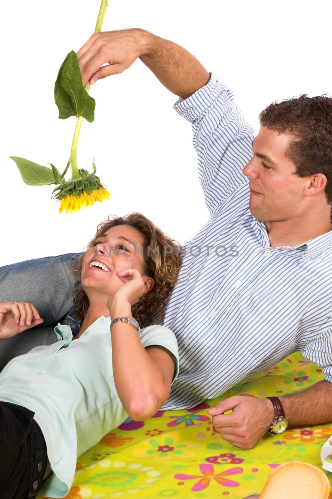 Young couple fooling around with a sunflower