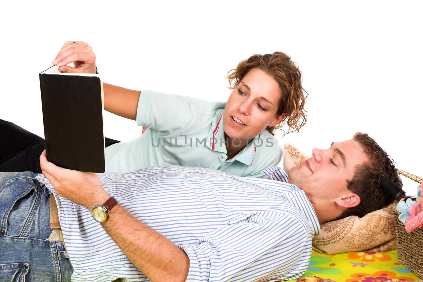 Young couple reading a book together on their picnic
