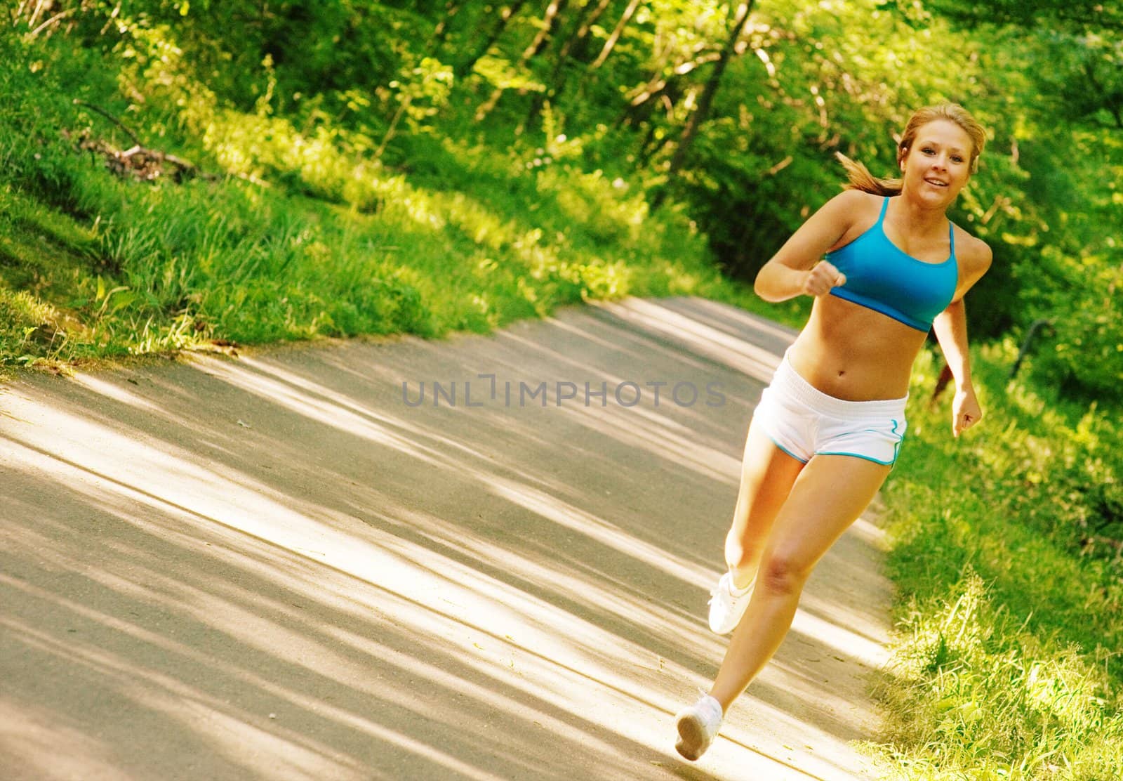 Young woman working out on a forest path.