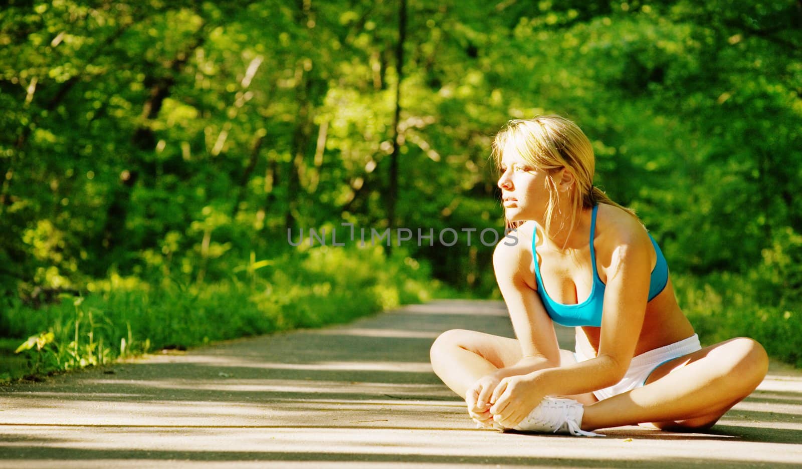 Young woman working out on a forest path.