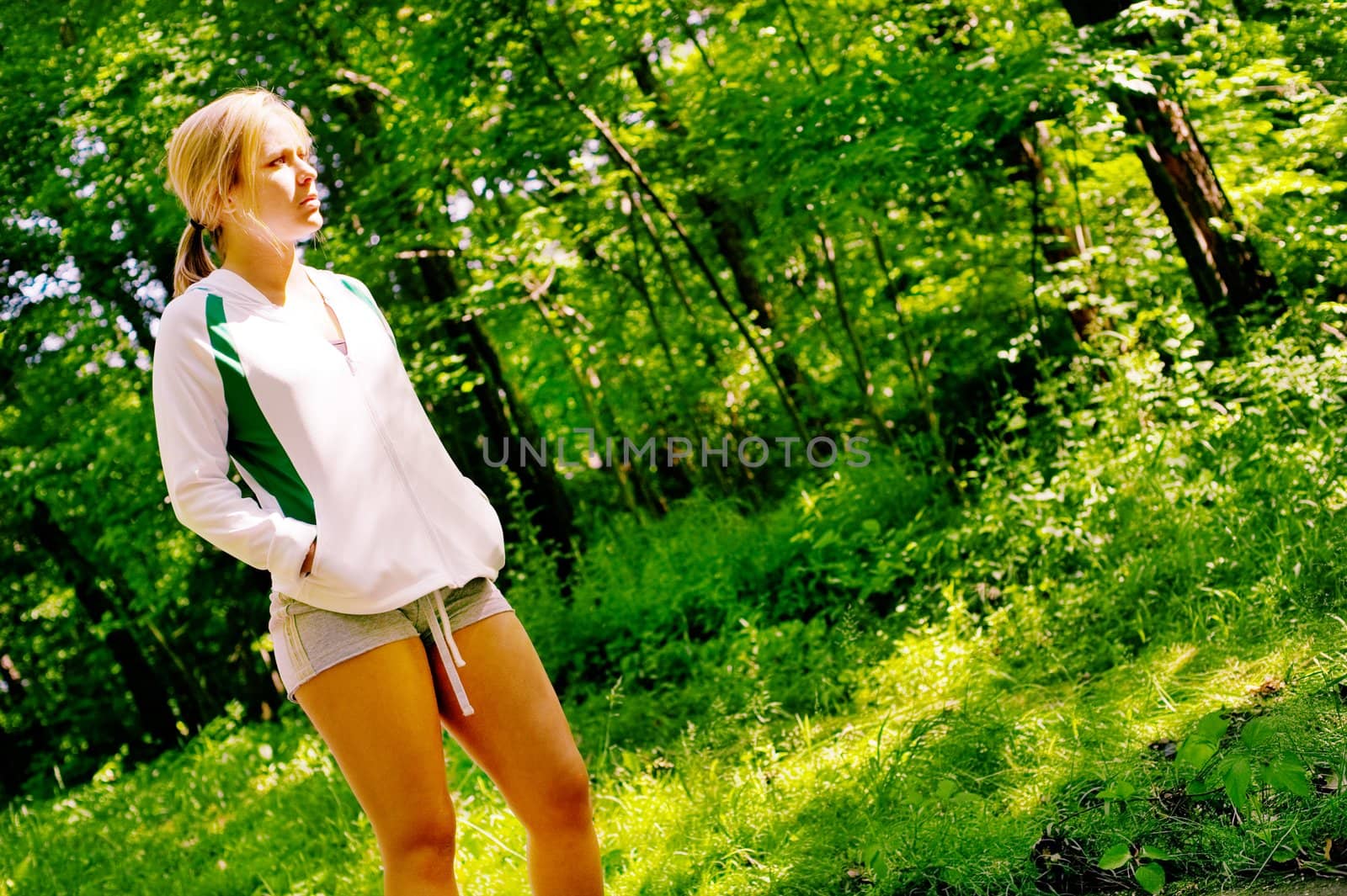 Young woman working out on a forest path.