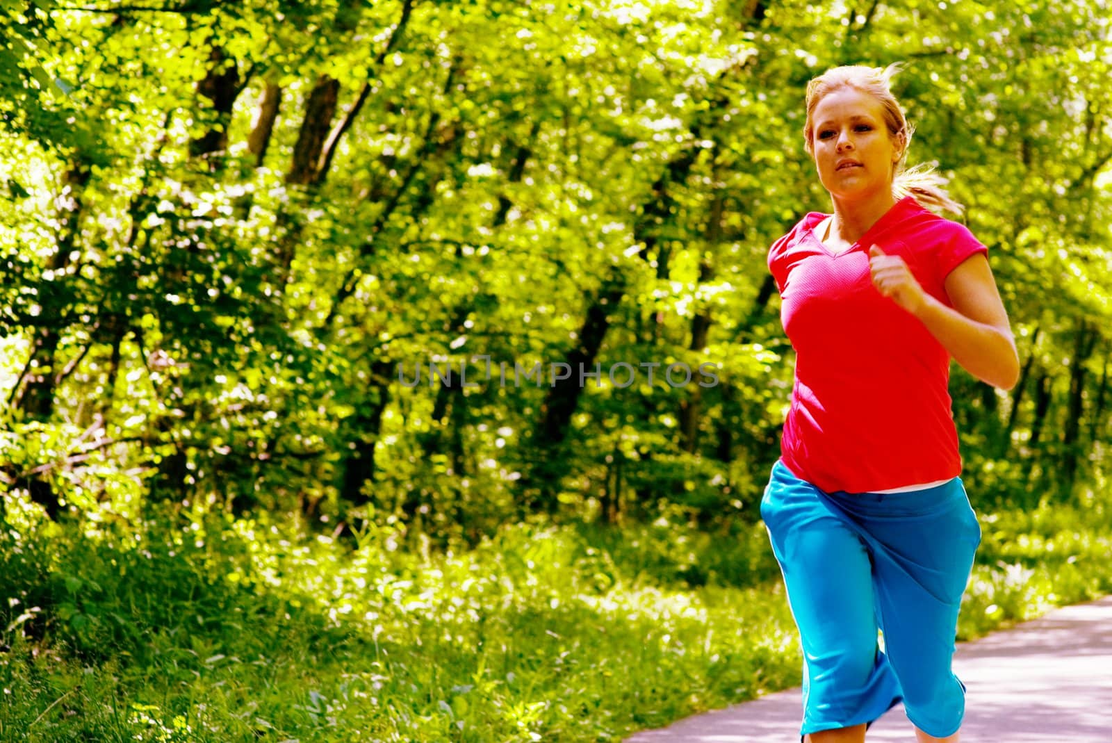 Young woman working out on a forest path.