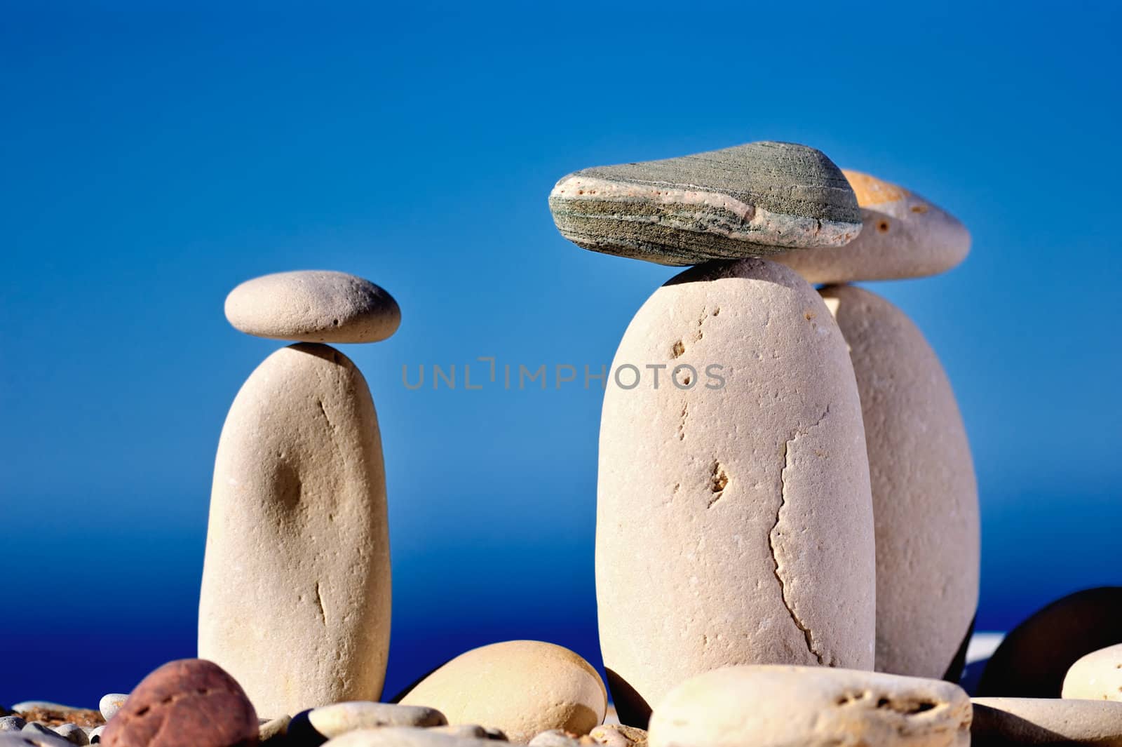 Three long white pebbles on a background of blue sky