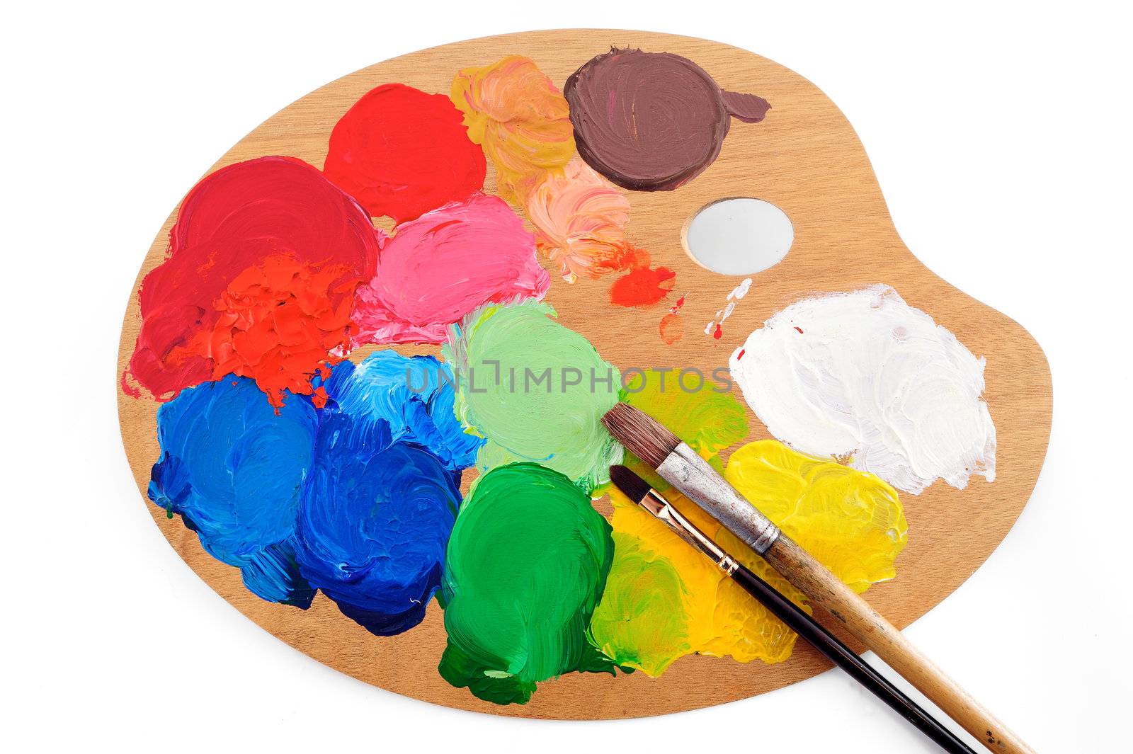 Paintbrushes on the palette with bright paints