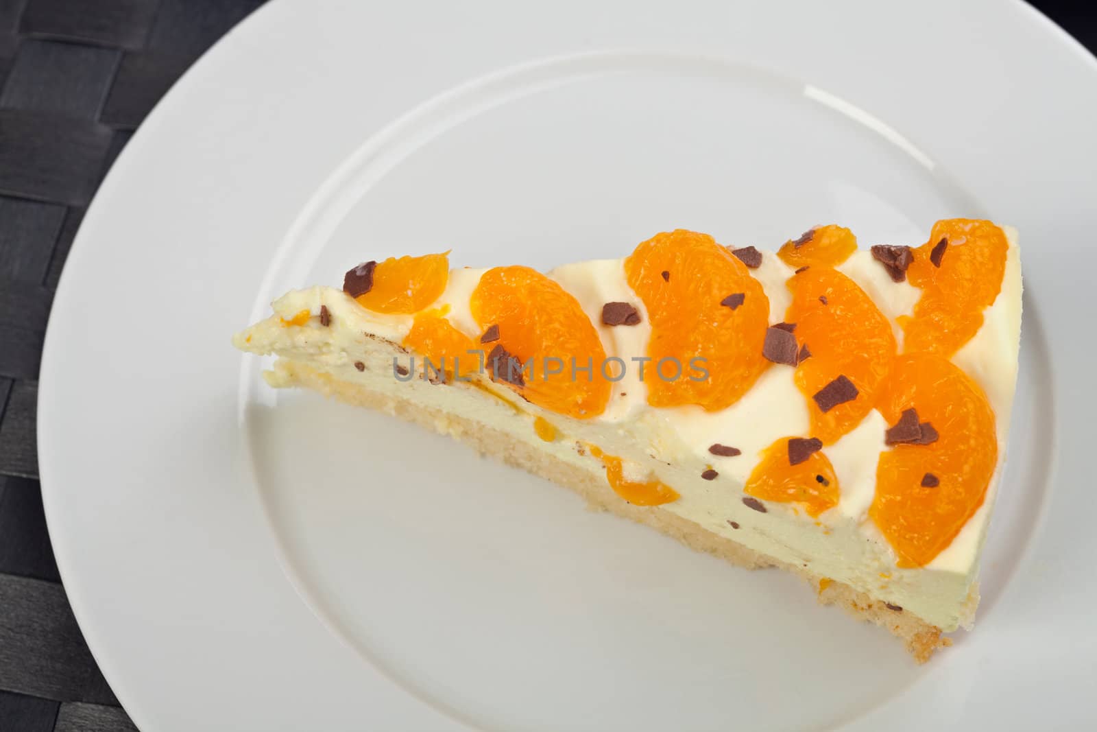 slice of tangerine cream cake on a white plate by bernjuer