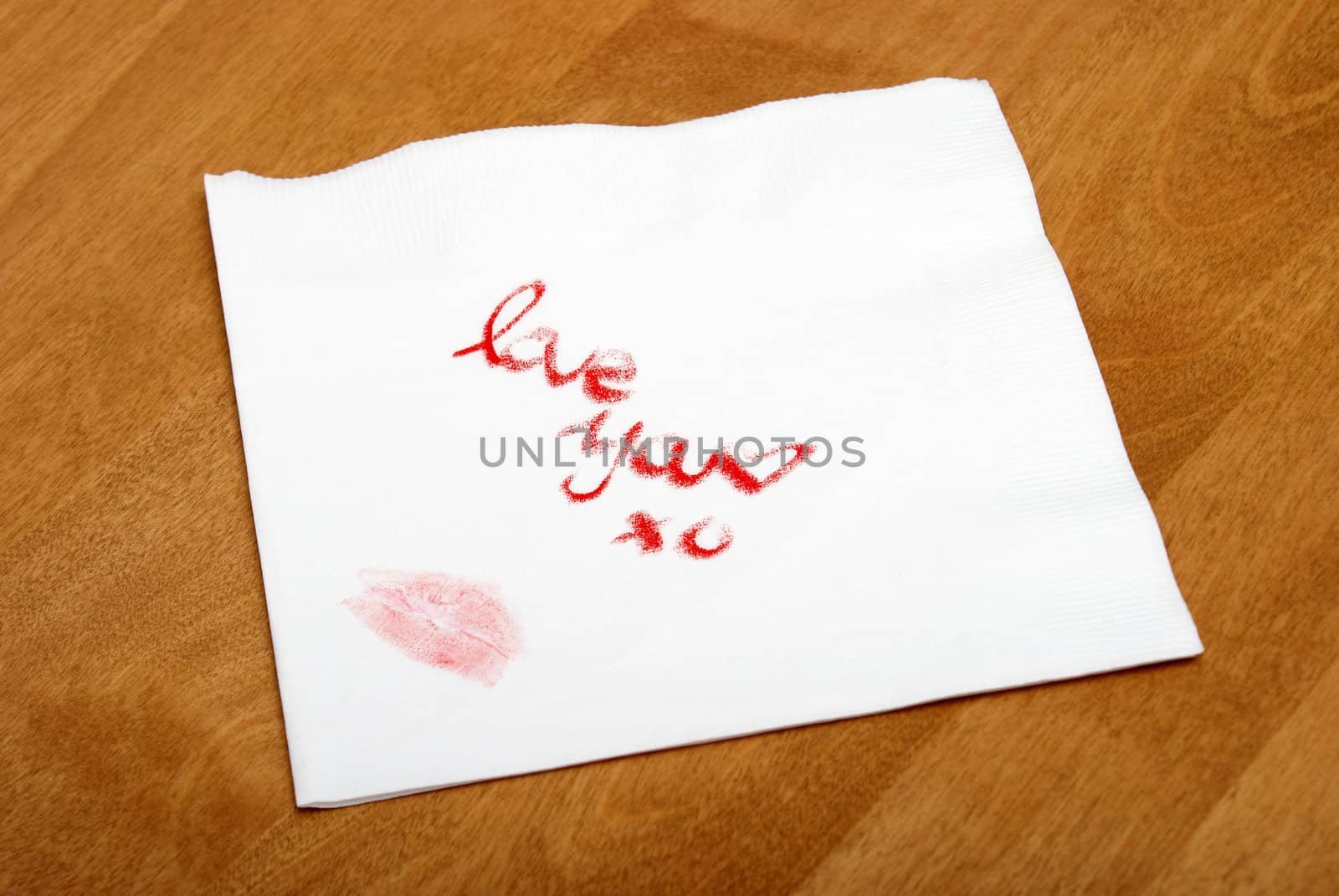 A woman writes a love note on a napkin with her lipstick.