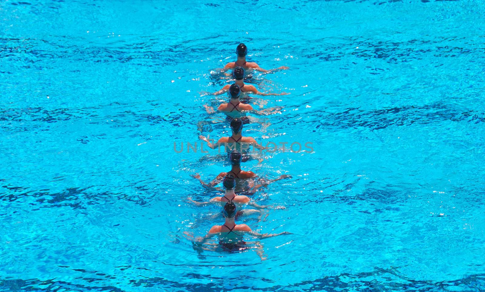 A seven women synchronized swimming team performing.
