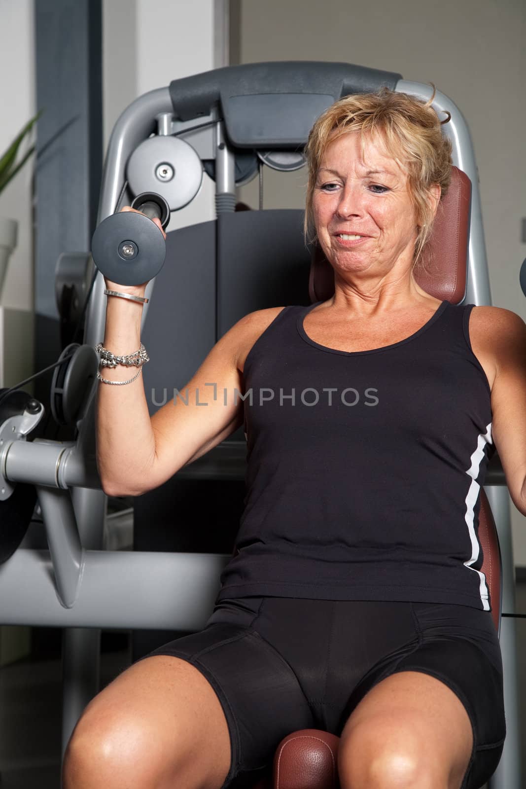 Mature woman working out on the fitness machines