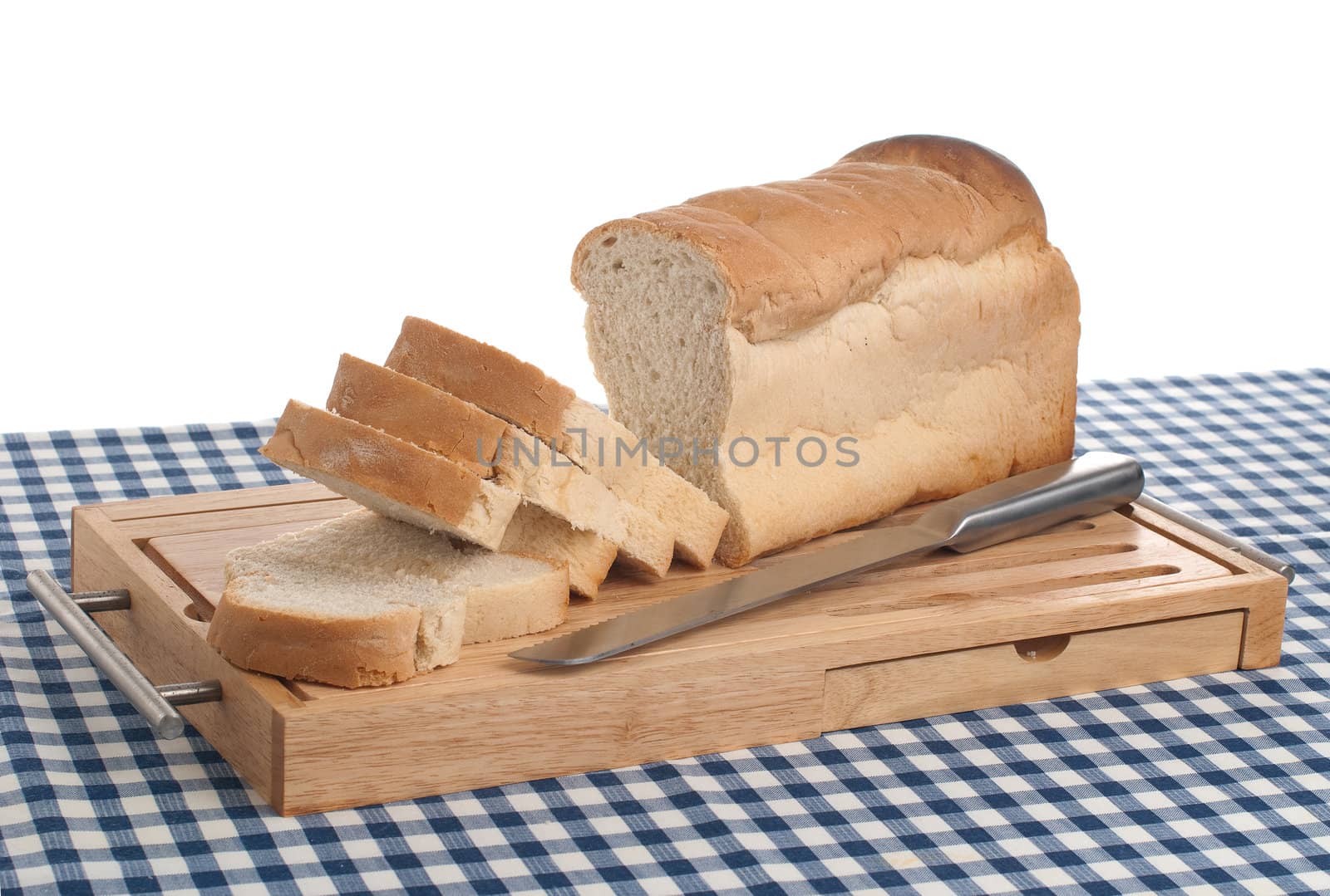 Slices of bread on top of wooden board and a blue square pattern towel.