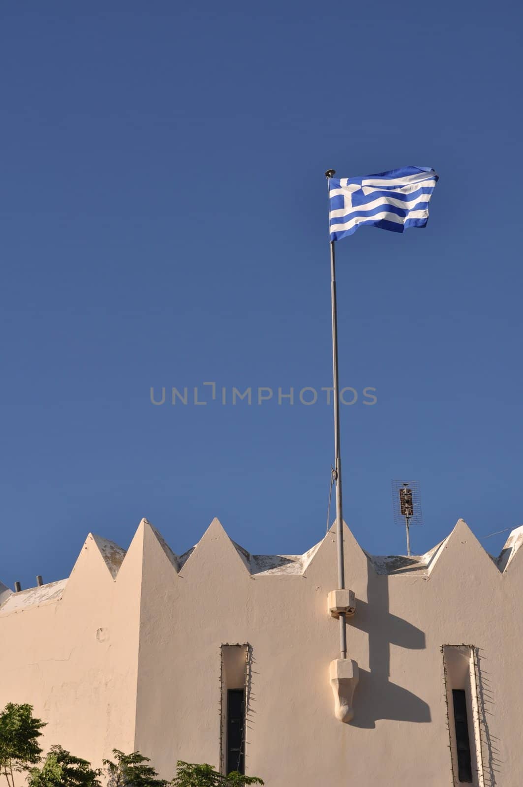 national flag of Greece on Kos town building (blue sky background)