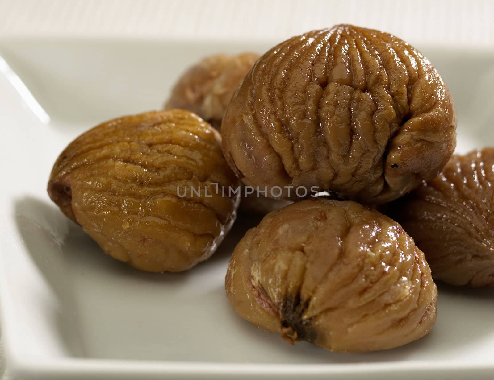 Five cooked chestnuts om white