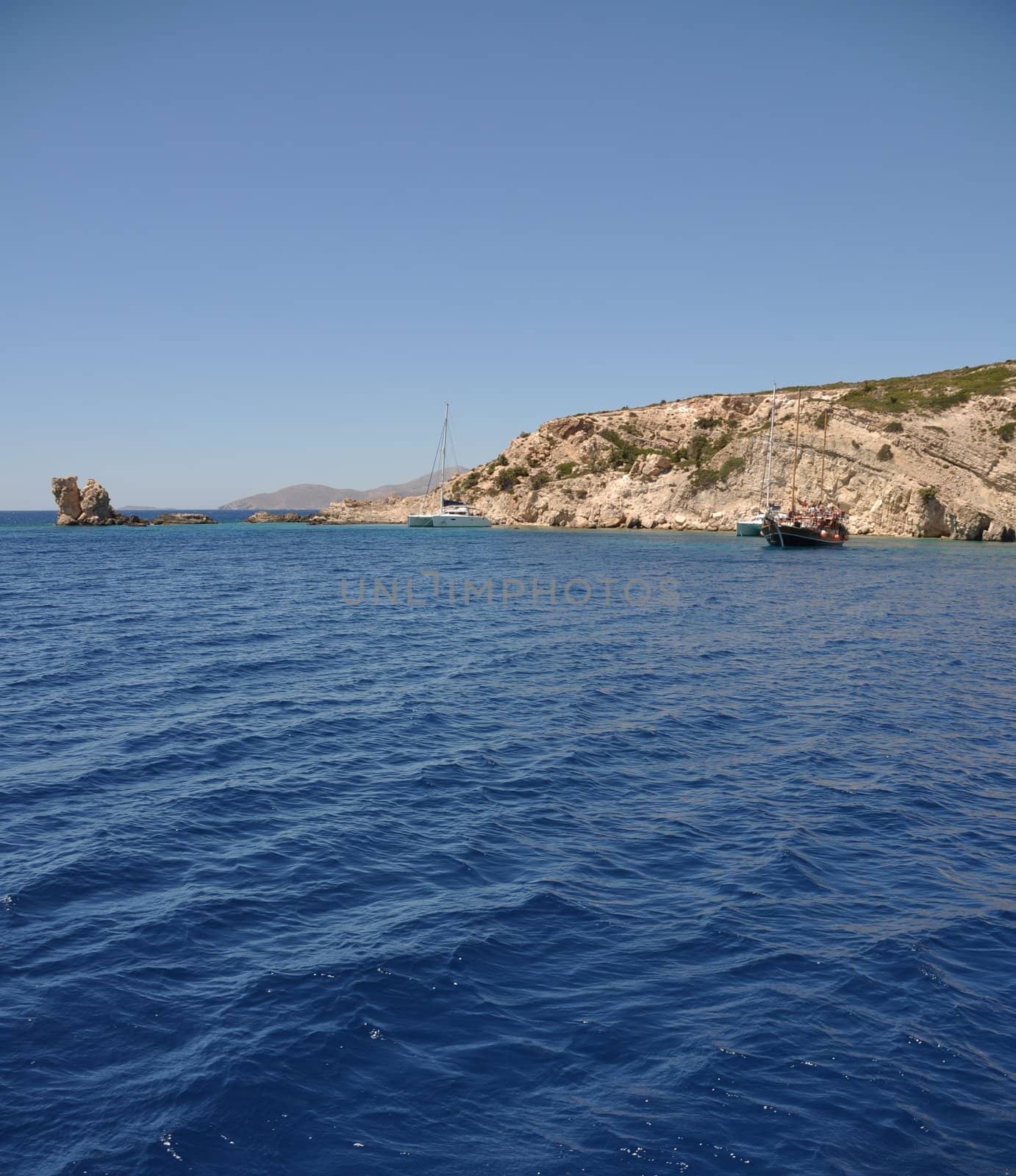 beautiful desert or uninhabited island in Greece with sailing/cruising boats