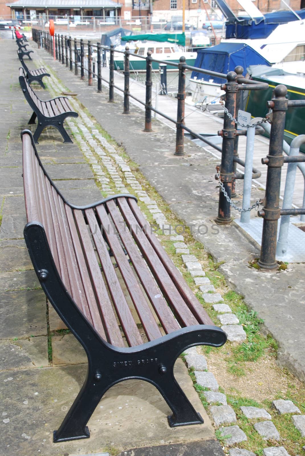 row of beautiful and wooden benchs at the docks in Gloucester, England UK