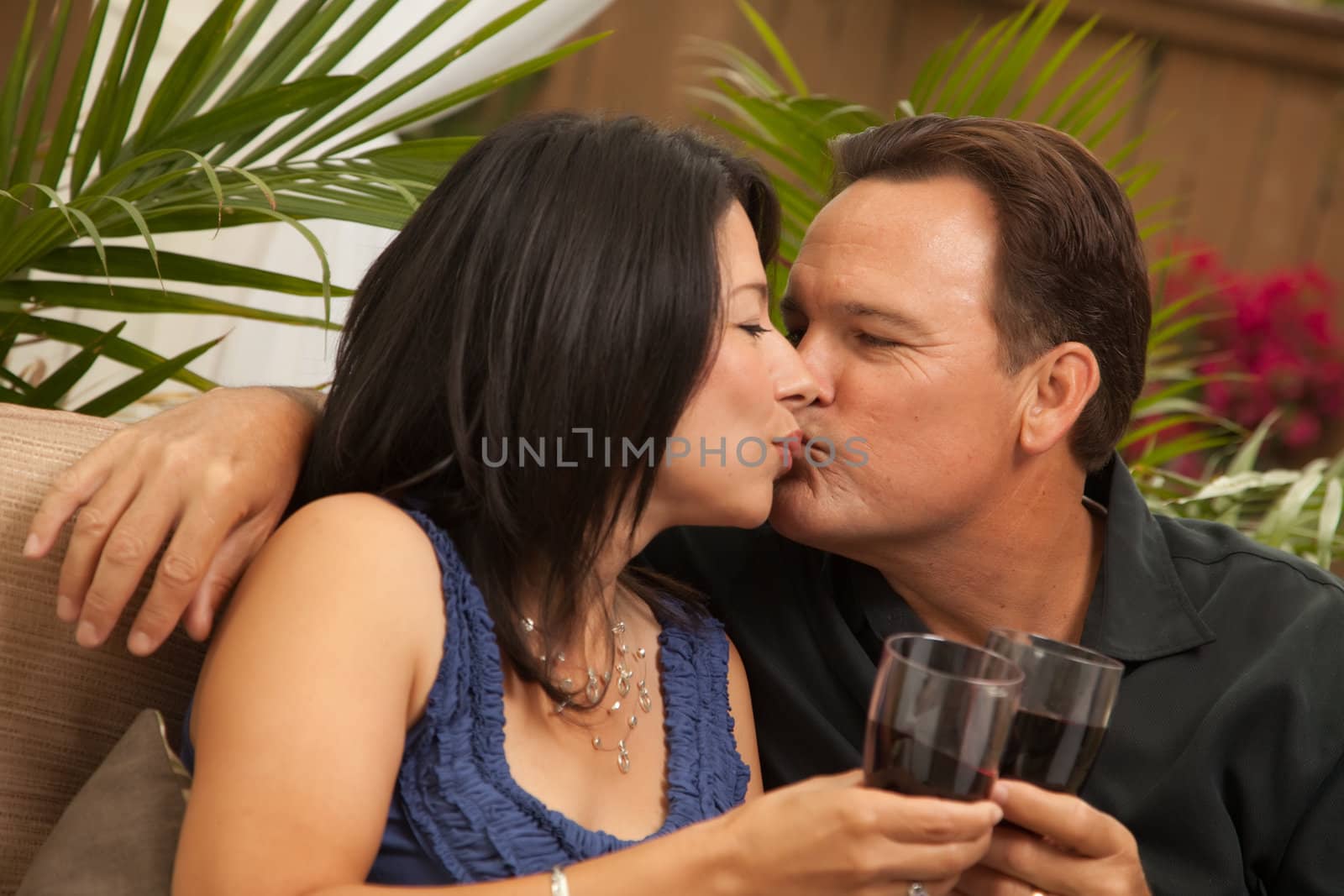 Attractive Hispanic and Caucasian Couple Drinking Wine Outside.