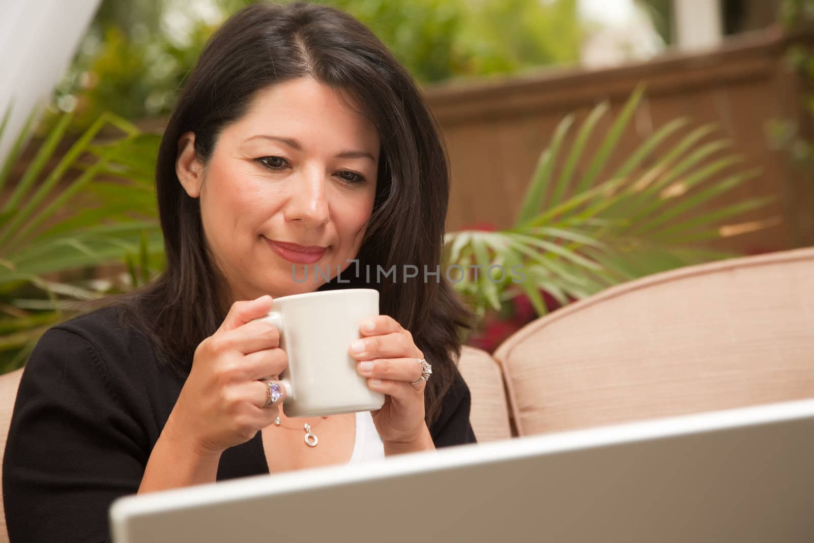 Hispanic Woman with Coffee and Laptop On Her Patio.