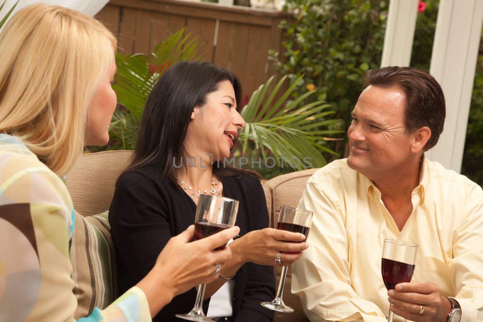 Three Friends Enjoying Wine on an Outdoor Patio.