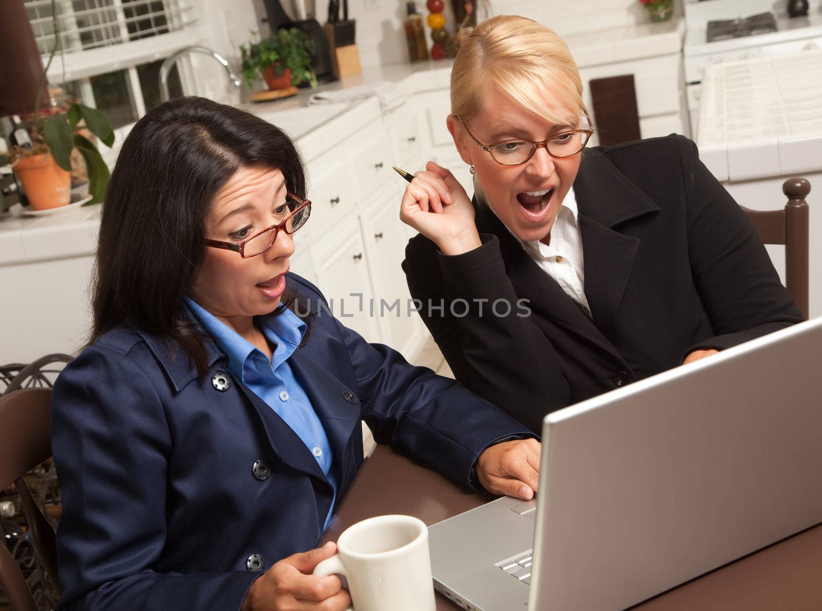 Businesswomen Celebrate Success on the Laptop in the Kitchen.