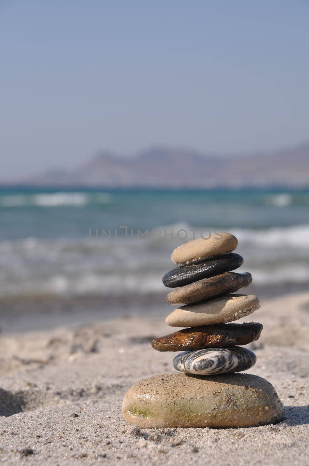 beautiful pebble stack on a sandy beach (sea on the background)