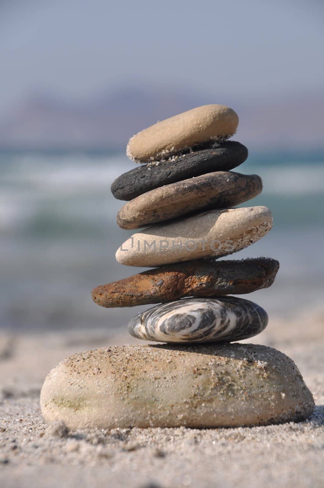 beautiful pebble stack on a sandy beach (sea on the background)