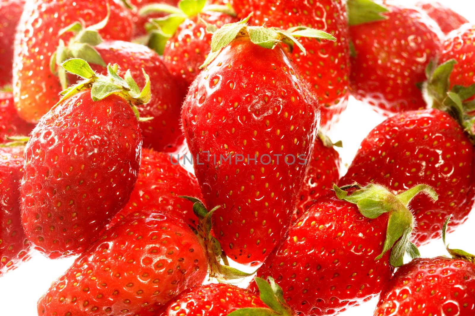 Red strawberries isolated on white surface close-up